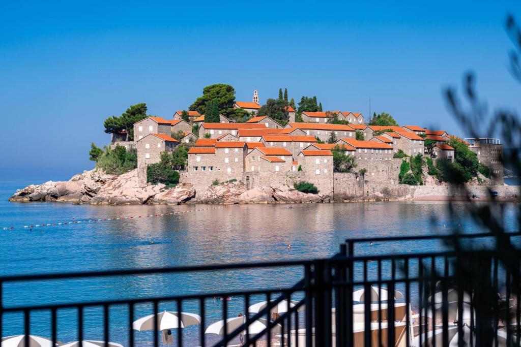 Skaists skats uz vēsturisko salu ar akmens ēkām un sarkaniem jumtiem, kas atrodas pie mierīgas jūras. Ideāla vieta atpūtai un brīvdienām.