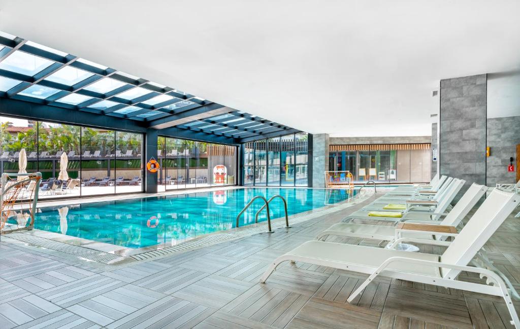 Iekštelpu peldbaseins ar sauļošanās krēsliem DoubleTree by Hilton Antalya-Kemer.