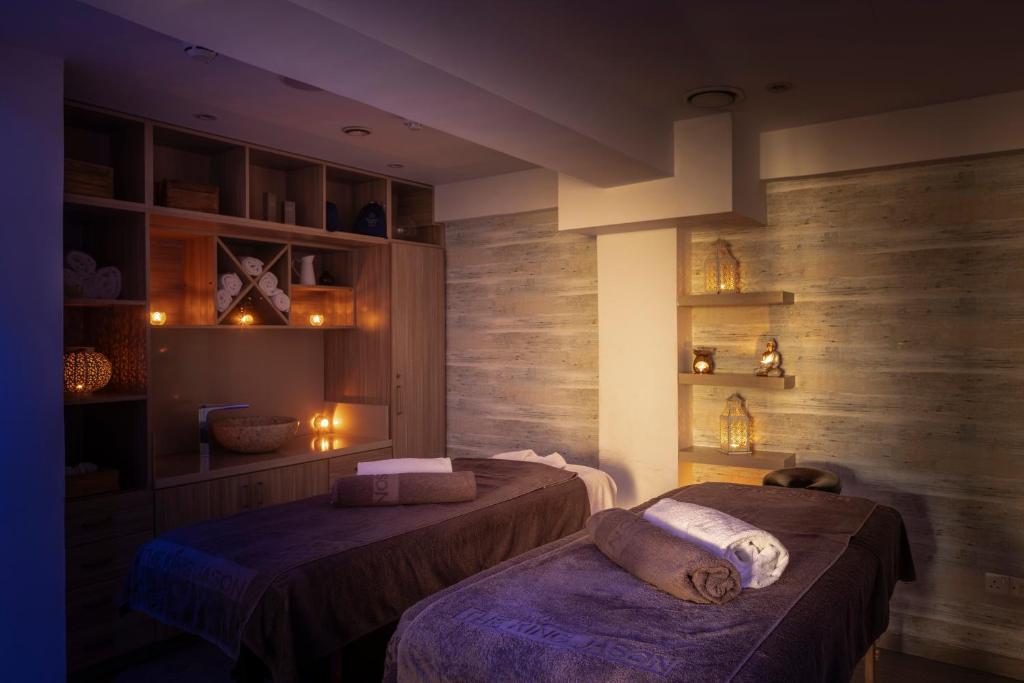 Relaksējoša spa telpa ar masāžas galdiem, svecēm un mājīgu apgaismojumu. Ideāli piemērota relaksācijai un labsajūtai.