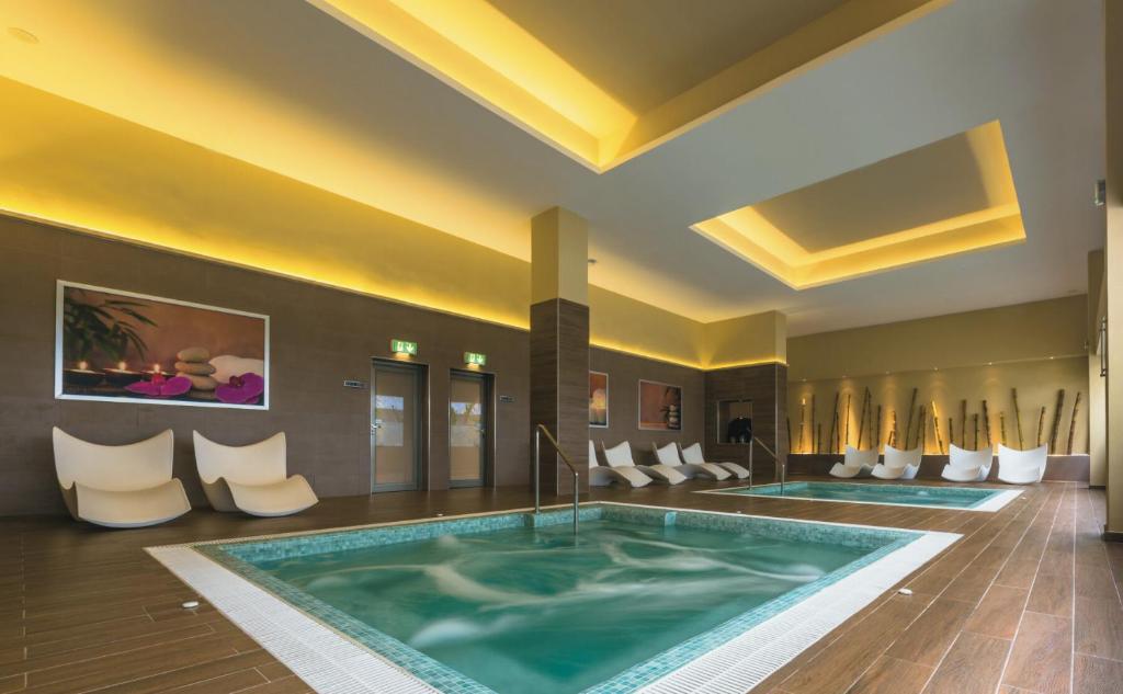 Mūsdienīgs spa ar relaksējošu atmosfēru, iekļaujot burbuļu baseinu un ērtas atpūtas krēslus. Gaismas un interjera elementi veido mierīgu vidi atpūtai.