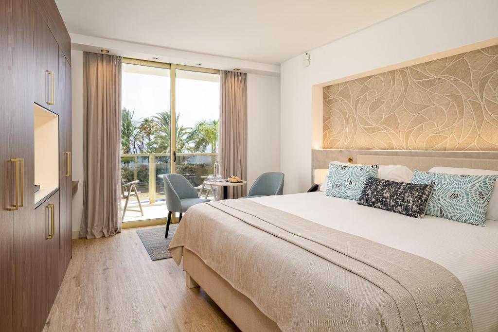 Mūsdienīgs viesnīcas numurs ar ērtu gultu, dekoratīviem spilveniem un lieliem logiem, kas paver skatu uz zāli un terasi. Numurā ir moderns dizains un komforts.