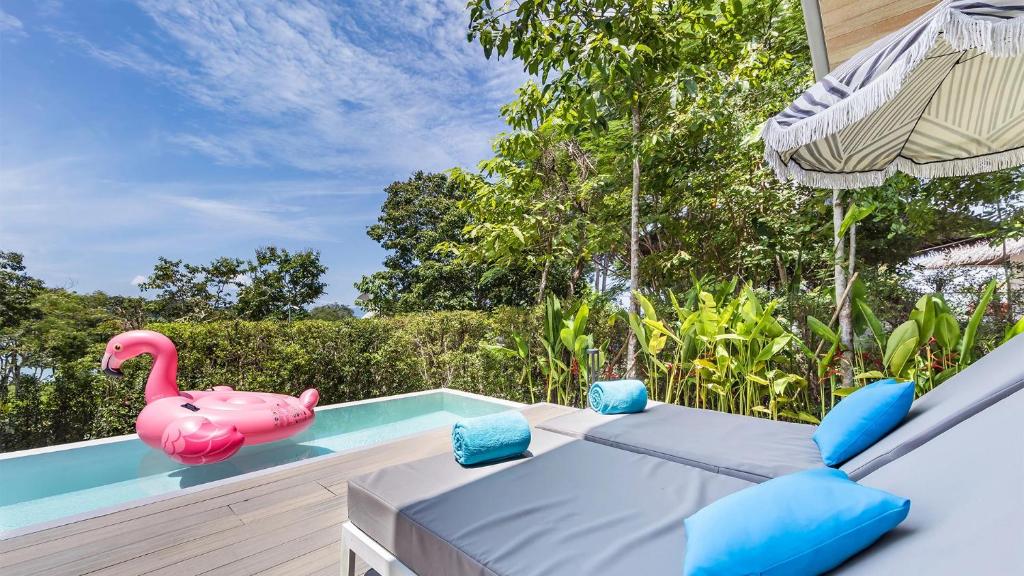 Atpūtas zona pie baseina hotelī Island Escape by Burasari ar rozā pīli