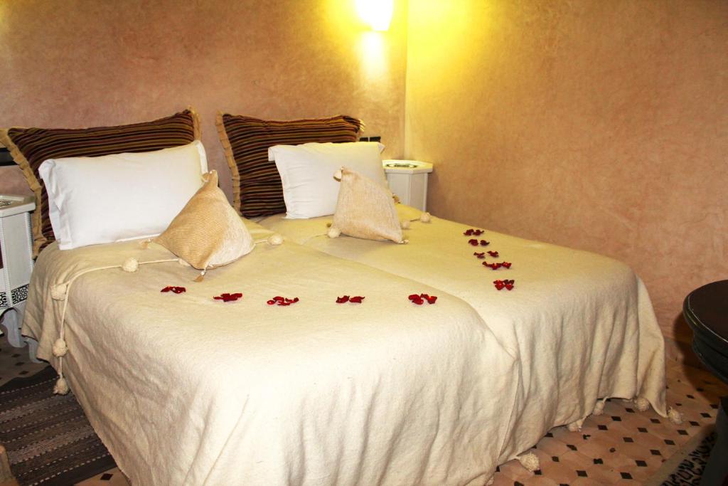 Romantiska guļamistaba ar divām gultām, dekorētām ar ziedlapiņām un spilveniem, siltā apgaismojumā. Ideāli piemērota romantiskām brīvdienām.