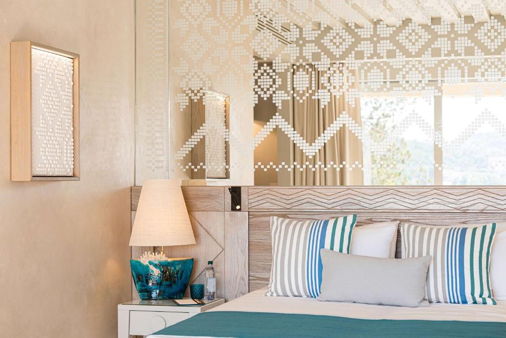 7 Pines Resort Sardinia elegants numurs ar dekoratīviem spilveniem.