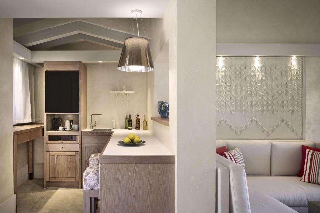 7 Pines Resort Sardinia elegant suite interior with kitchenette.