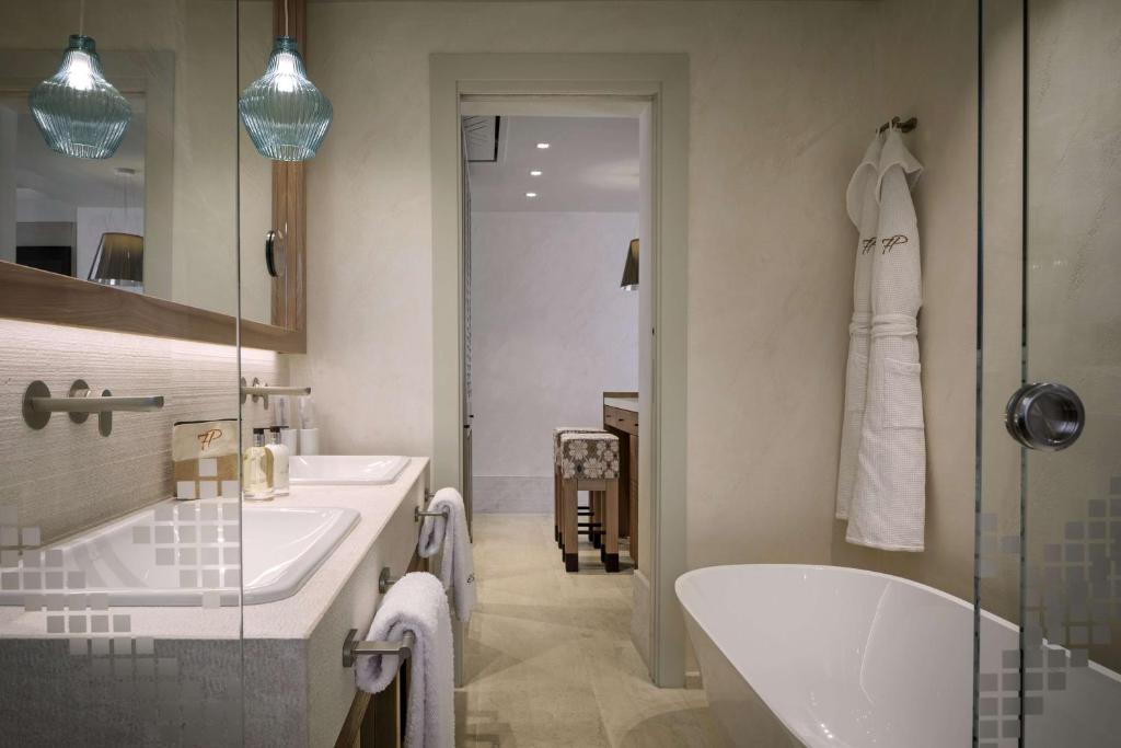 Vannas istaba viesnīcā 7 Pines Resort Sardinia ar modernu dizainu.