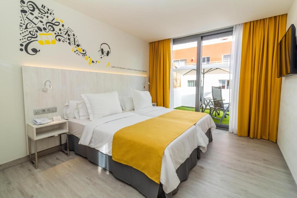 Mūzikas tematikas viesnīcas numurs ar divām gultām, dzelteniem aizkariem un balkonu. Interjers ir moderns un gaišs, radot patīkamu atmosfēru.