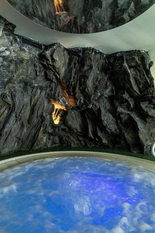 Mūsdienīga spa zona ar dabisku akmens sienu un burbuļvannu, kas izgaismota ar zilu gaismu. Ideāla vieta relaksācijai un atpūtai.