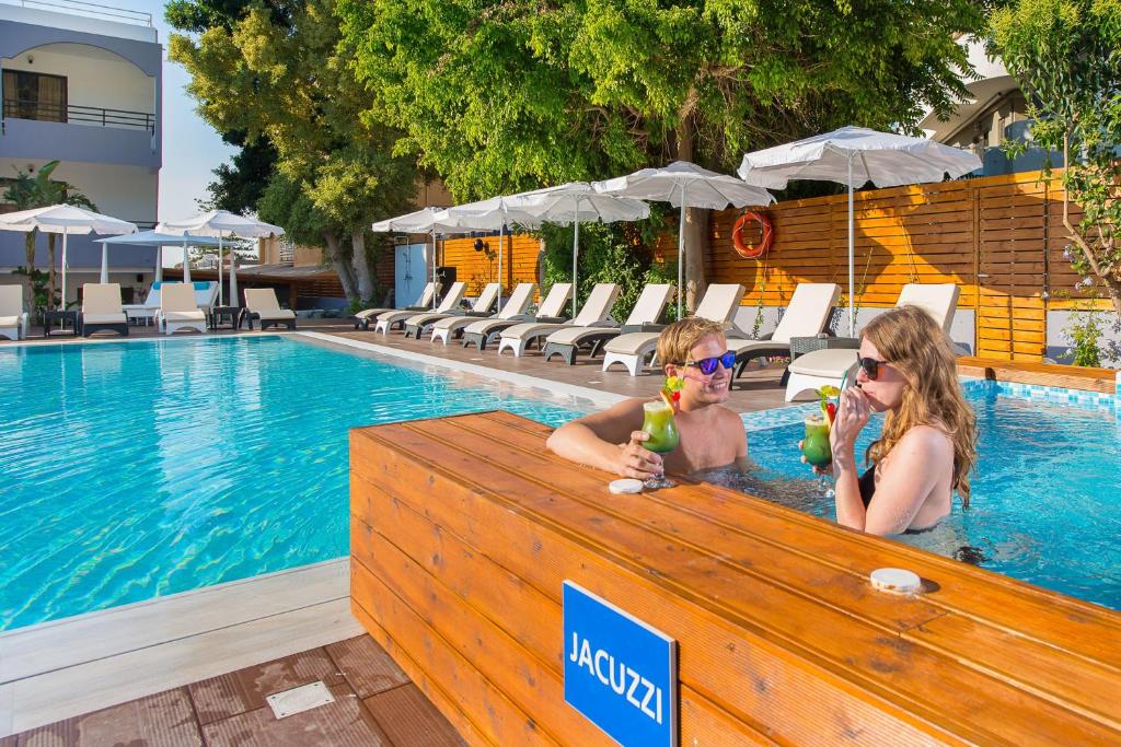 Pāris izbauda kokteiļus džakuzi pie Sunny Days Hotel-Apartments.