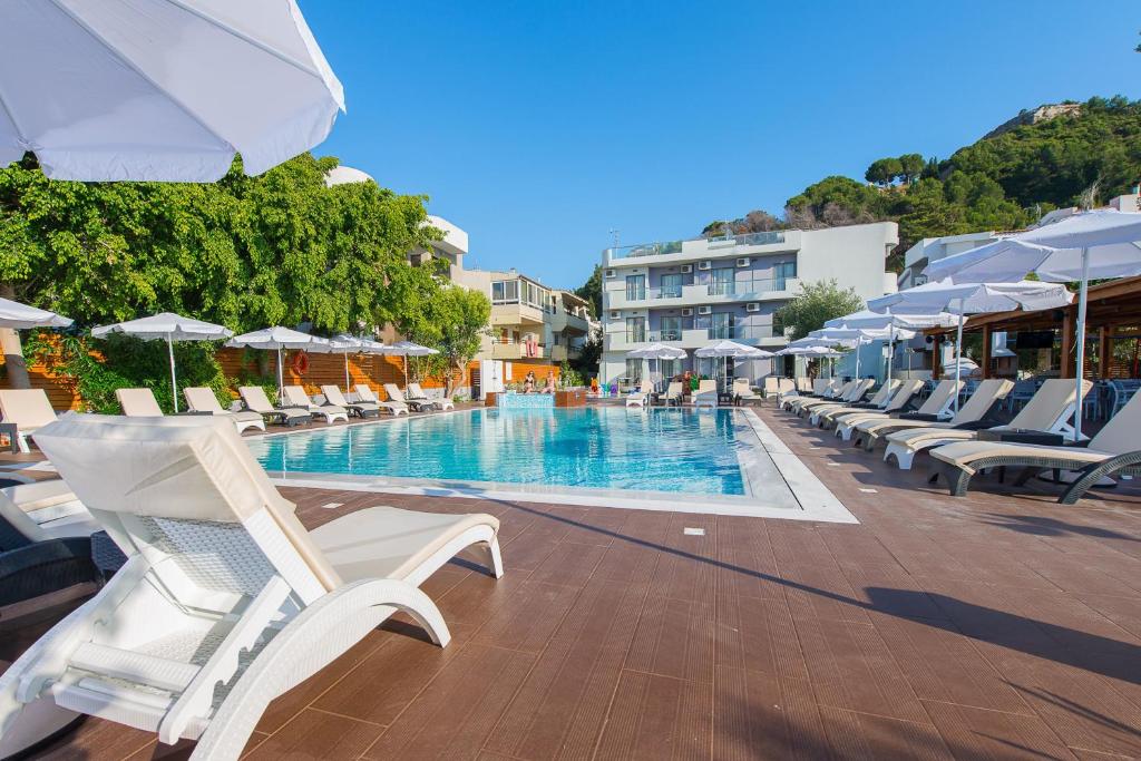 Peldbaseins pie Sunny Days Hotel-Apartments ar sauļošanās krēsliem.