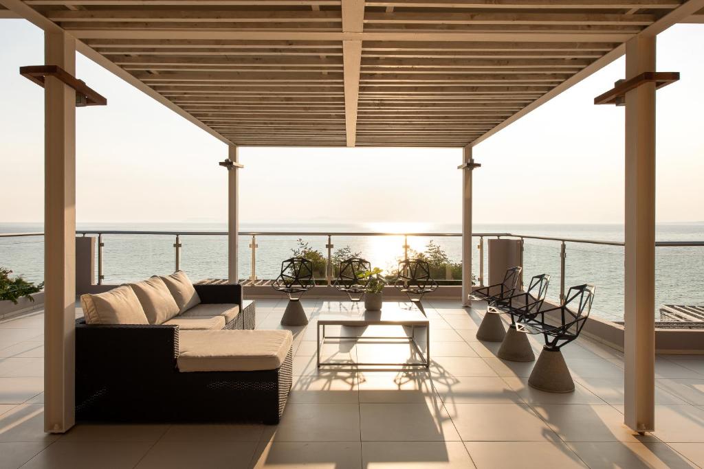 Mūsdienīgs terases dizains ar panorāmas skatu uz jūru, ērti dīvāni un stilīgi krēsli, kas rada relaksējošu atmosfēru. Ideāla vieta atpūtai un baudīšanai.