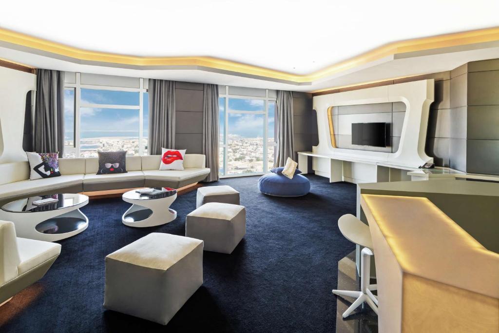 Mūsdienīgs un elegants viesnīcas numurs ar panorāmas logiem, kas piedāvā skatu uz pilsētu. Interjers ir veidots ar modernām mēbelēm un stilīgām dekorācijām.