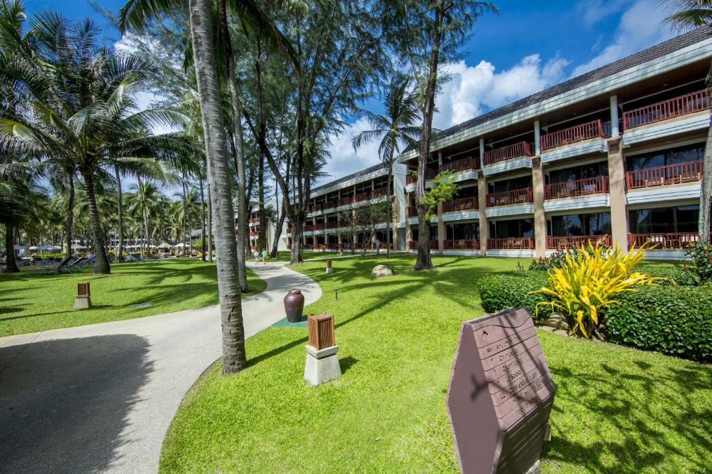 Katathani Phuket Beach Resort dārza ainava ar kokiem un numuriem