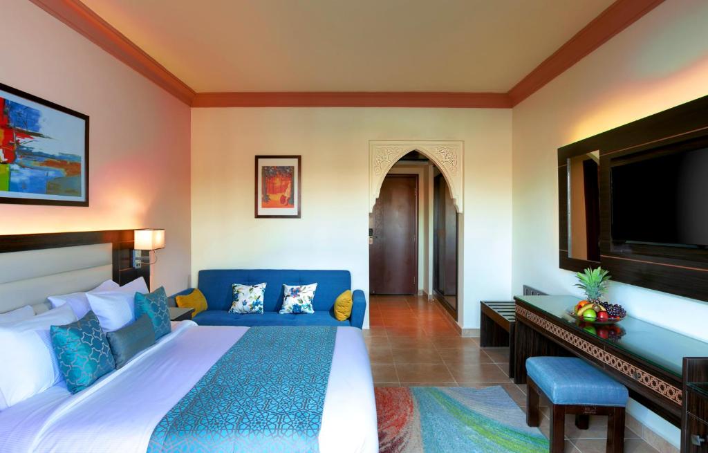 Mūsdienīgs numurs Albatros Palace Resort ar dīvānu un televizoru.