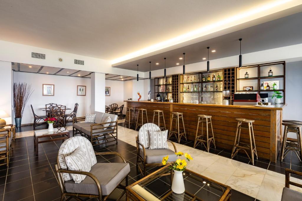 Mūsdienīgs bārs ar elegantiem krēsliem un stilu, kurā ir pieejami dažādi dzērieni. Telpa ir gaiša un viesmīlīga, radot patīkamu atmosfēru atpūtai.