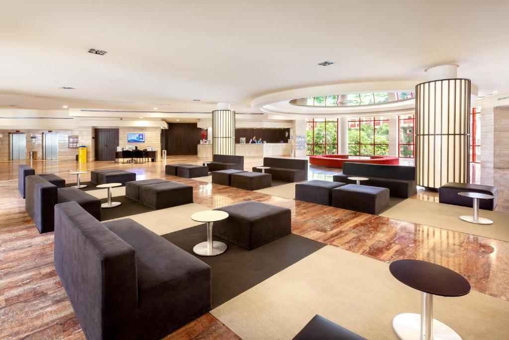Mūsdienīgs viesnīcas vestibils ar melniem dīvāniem un stilīgām kafijas galdiņām, kas rada relaksējošu atmosfēru. Lieliski piemērots atpūtai vai tikšanās brīžiem.