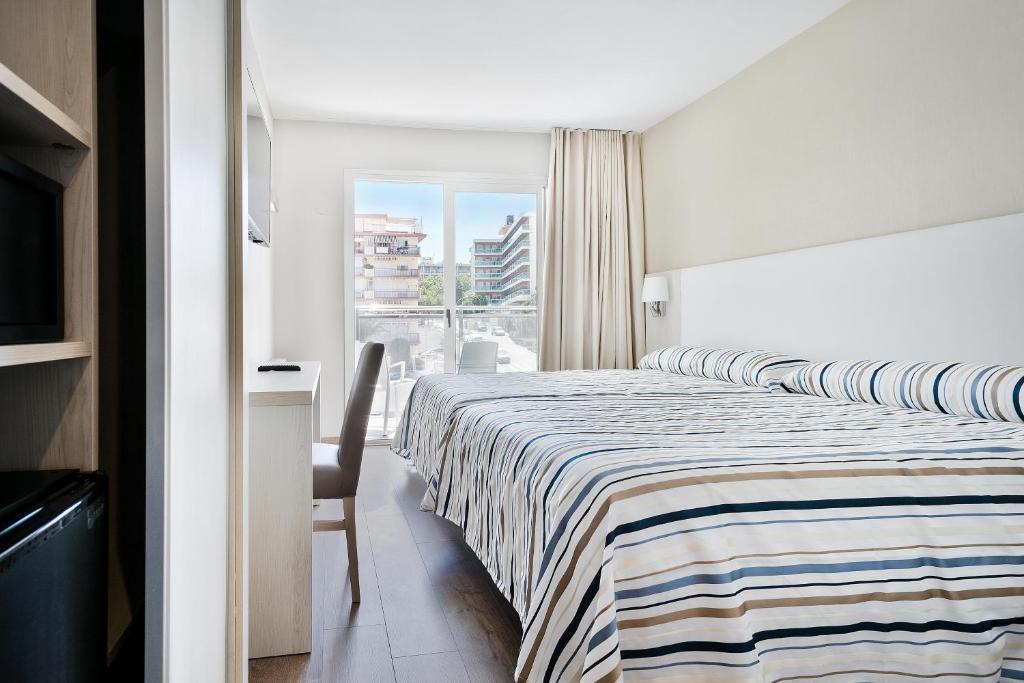 Gaišs Best San Diego viesnīcas numurs ar balkonu un svītrainu gultas veļu