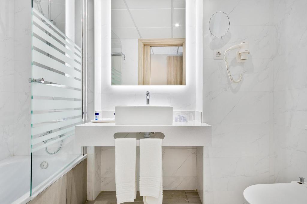 Best San Diego viesnīcas moderna vannas istaba ar baltu izlietni, apgaismotu spoguli un dušas zonu.