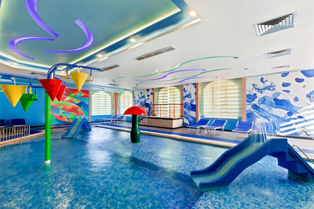 Iekštelpūļa baseins ar slidkalniņu un krāsainiem rotaļu elementiem, Pickalbatros Dana Beach Resort