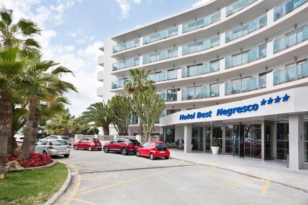Moderns viesnīcas ārskats ar palmām un automašīnām, atrodas pie ieejas "Hotel Best Negresco". Viesnīca piedāvā mūsdienīgas ērtības un pievilcīgu arhitektūru.
