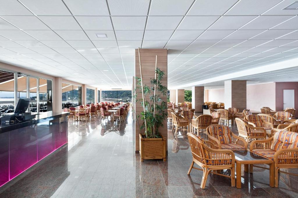 Moderns restorāns ar plašu interjeru, koka mēbelēm un lieliem logiem, kas piedāvā skatu uz dabu. Gaismas un elegances apvienojums, ideāli piemērots relaksācijai.