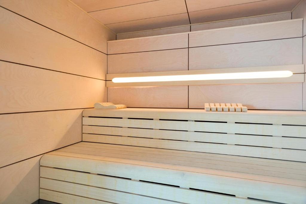 Mūsdienīga sauna ar koka sienām un vienkāršu dizainu, kas nodrošina relaksējošu atmosfēru. Gaisma un siltums rada patīkamu vidi atpūtai.