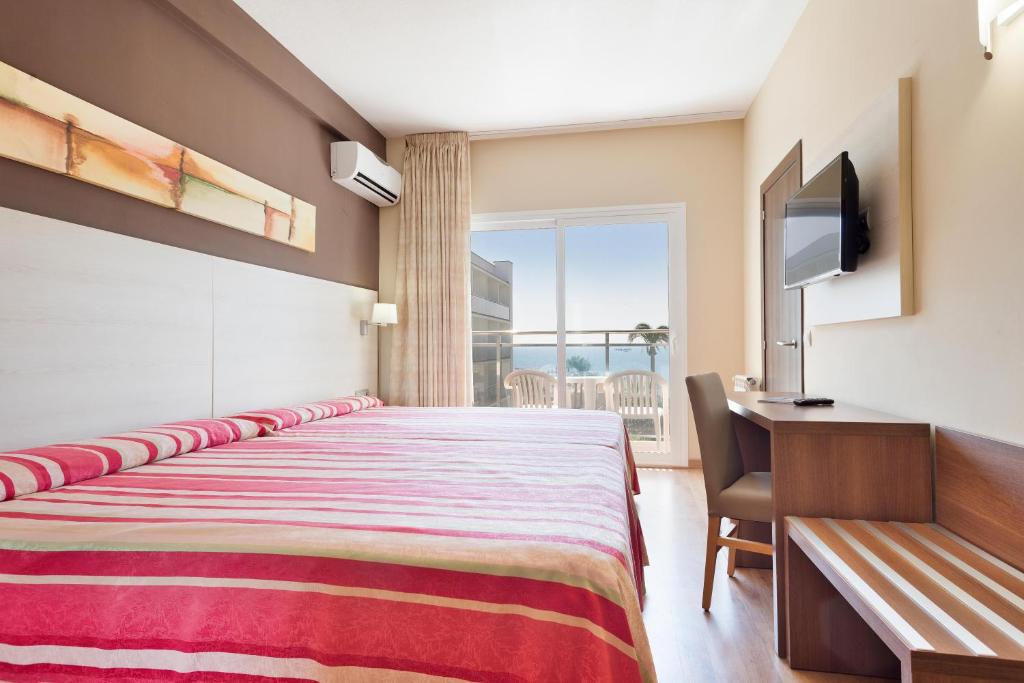 Mūsdienīgs viesnīcas numurs ar divām gultām, dekorētu ar rozā un baltu svītrām, kā arī ar skatu uz jūru. Telpā ir ērtas mēbeles, televizors un balkons ar piekļuvi ārējai terasei.