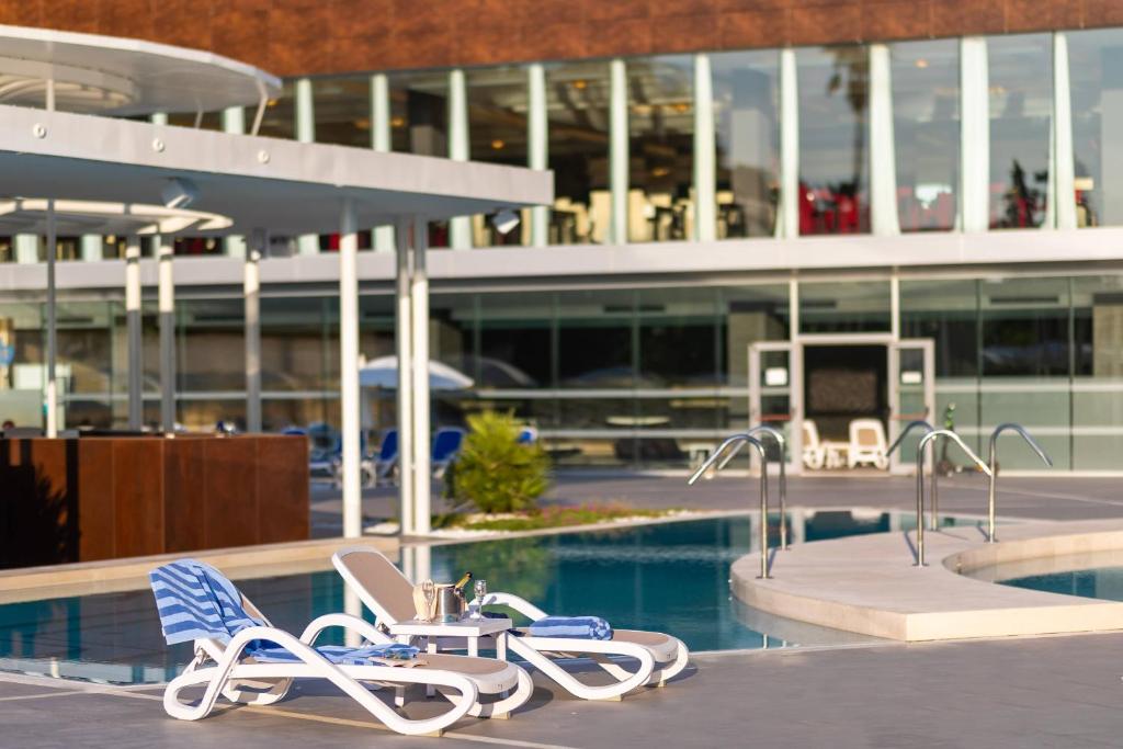 Baseins ar atpūtas krēsliem un bāru, modernā vidē. Ideāla vieta relaksācijai un atpūtai.