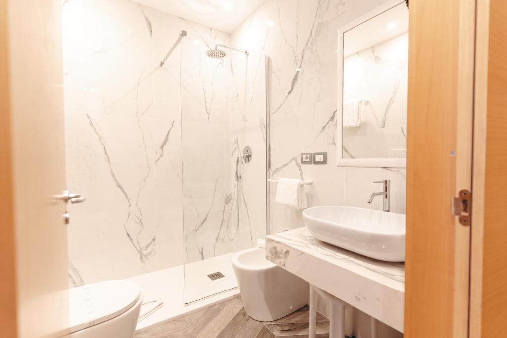 Mūsdienīgs un stilīgs vannas istabas interjers ar marmora apdari, dušu un modernām sanitārajām ierīcēm. Eleganta izskata izlietne un daudz gaismas.