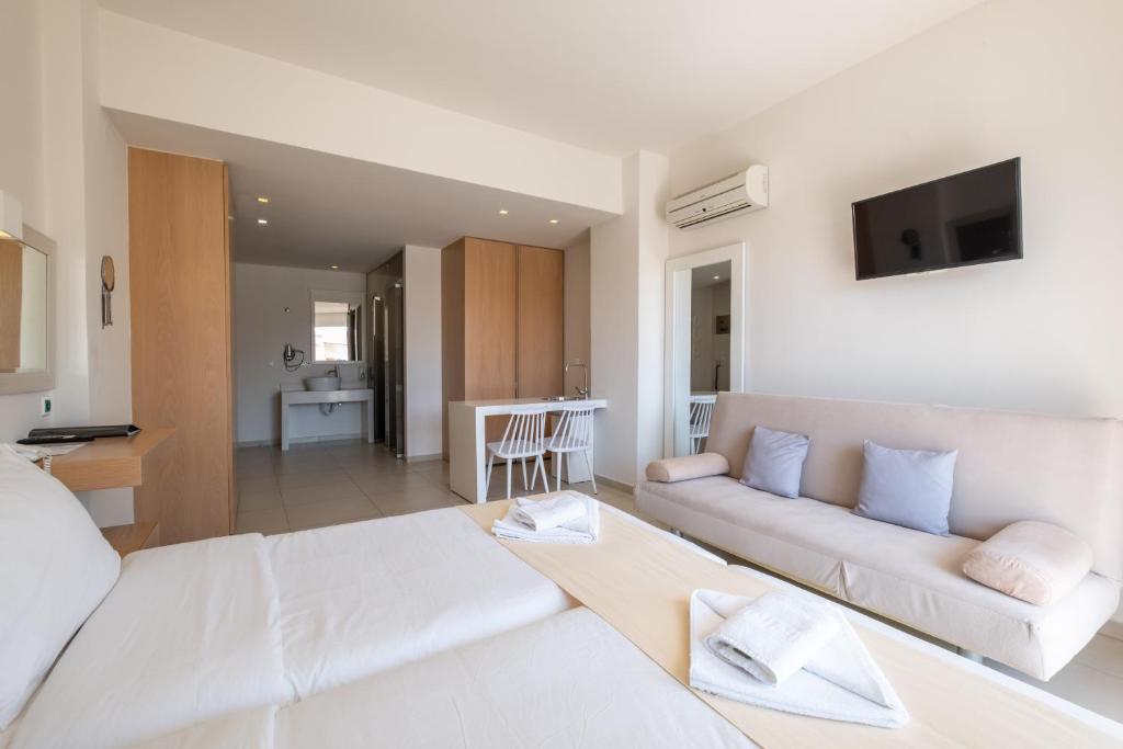 Moderns viesnīcas numurs ar gaišām sienām, divām gultām un atpūtas zonu, kurā ir dīvāns un galda zona. Numurā ir arī televizors un vannas istaba.