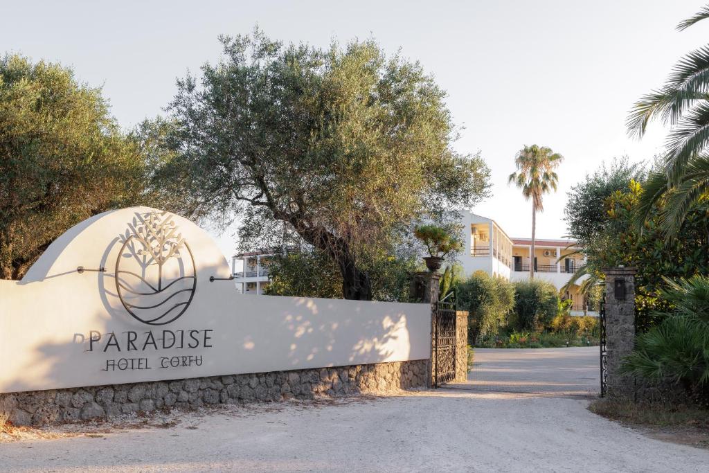 Ieiešana viesnīcā "Paradise" Korfu, apzaļumota teritorija ar olīvkoku un palmu ainavu.