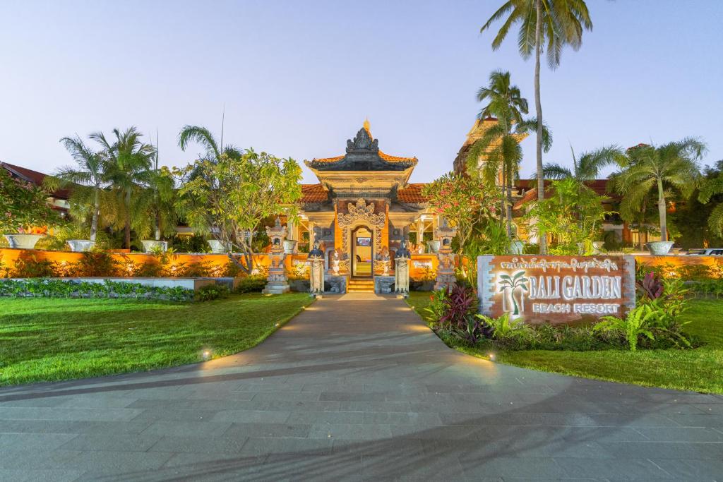Bali Garden Beach Resort ieeja ar tradicionālo arhitektūru un tropisko ainavu, kas radīs relaksējošu atmosfēru. Jaukais zīmolplakāts un zaļā vide pievērš uzmanību viesnīcas burvībai.