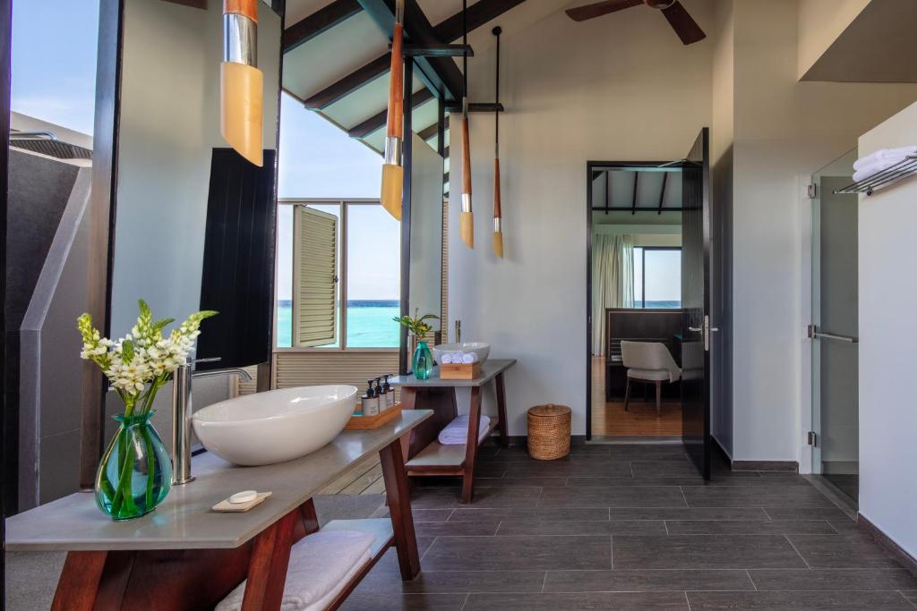 Mūsdienīgs vannas istabas interjers ar dabīgām gaismām, elegantu izskatu un skatu uz jūru. Tiek izmantoti koka un stikla elementi, radot relaksējošu atmosfēru.