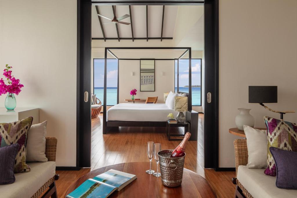 Mūsdienīgs viesnīcas numurs ar plašu skatu uz jūru, elegantiem interjera elementiem un ziedu kompozīciju uz galda. Ideāla atmosfēra atpūtai un relaksācijai.