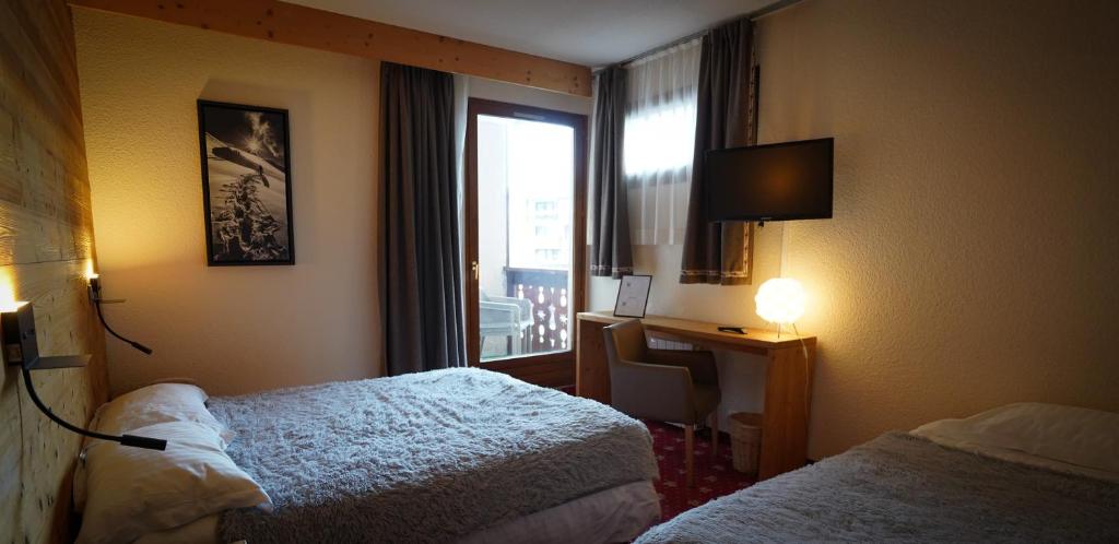 Mūsdienīgs viesnīcas numurs ar divām gultām, rakstāmgaldu un televizoru. Telpā ir lieli logi ar piekļuvi balkonam, kas nodrošina dabīgu apgaismojumu.