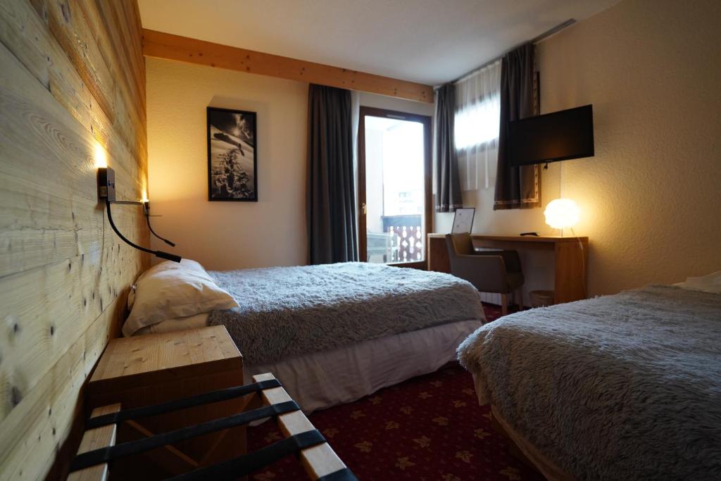 Mūsdienīgs viesnīcas numurs ar diviem gultām, koka sienām un televizoru, kas piedāvā komfortu un siltumu. Iespējama piekļuve balkonam ar skatu uz ārpusi.