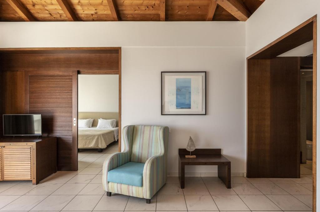 Mūsdienīgs viesnīcas numurs ar koka griestiem, gaišām flīzēm un ērtiem mēbeļiem, tostarp krēslu un televizoru. Interjers ir minimāls ar mākslas darbu uz sienas un piekļuvi guļamistabai.