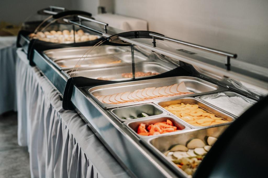 Buffet stila galda ar dažādām pārtikas sastāvdaļām, tostarp gaļas, dārzeņu un augļu šķēlēm. Svaigas un krāsainas izvēles, kas piemērotas svinībām vai pasākumiem.