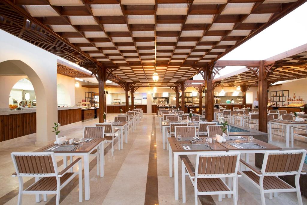 Moderns restorāns ar elegantiem koka galdiem un krēsliem, kas veidots ar gaišu interjeru un siltu apgaismojumu. Telpa ir plaša un gaisa, ar vairākiem ēdināšanas stendiem un rūpīgi izstrādātiem dekoriem.