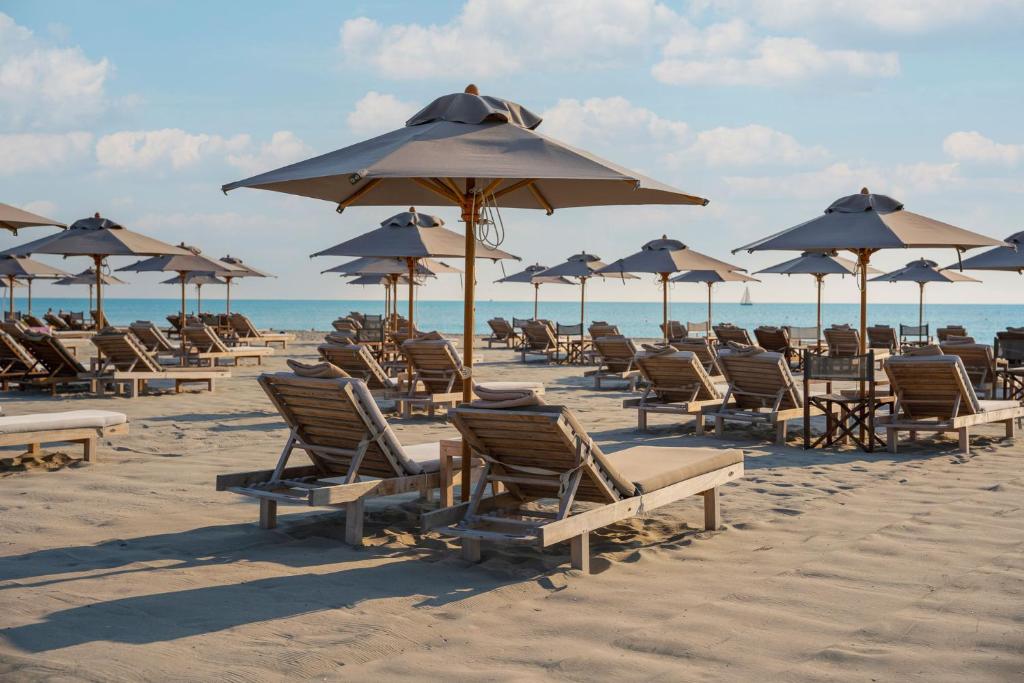 Pludmales gultas un saulessargi, kas izvietoti smiltīs pie jūras, radot relaksējošu atmosfēru brīvdienām.