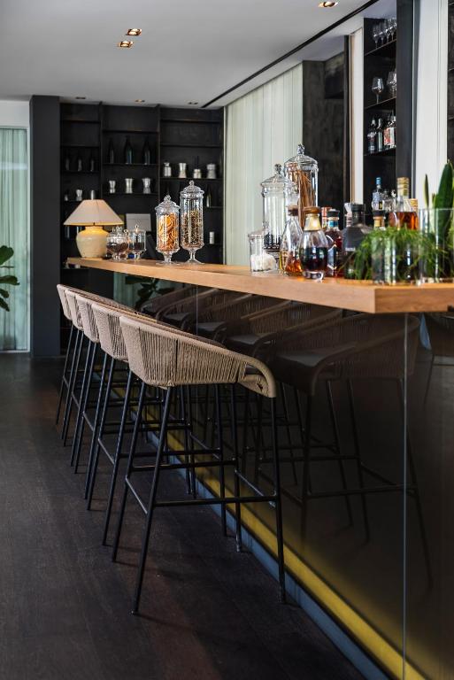 Mūsdienīgs bārs ar koka letes un stilīgām krēsliem, kas rotāts ar glāzēm un augiem. Interjers ir elegants un aicinošs.