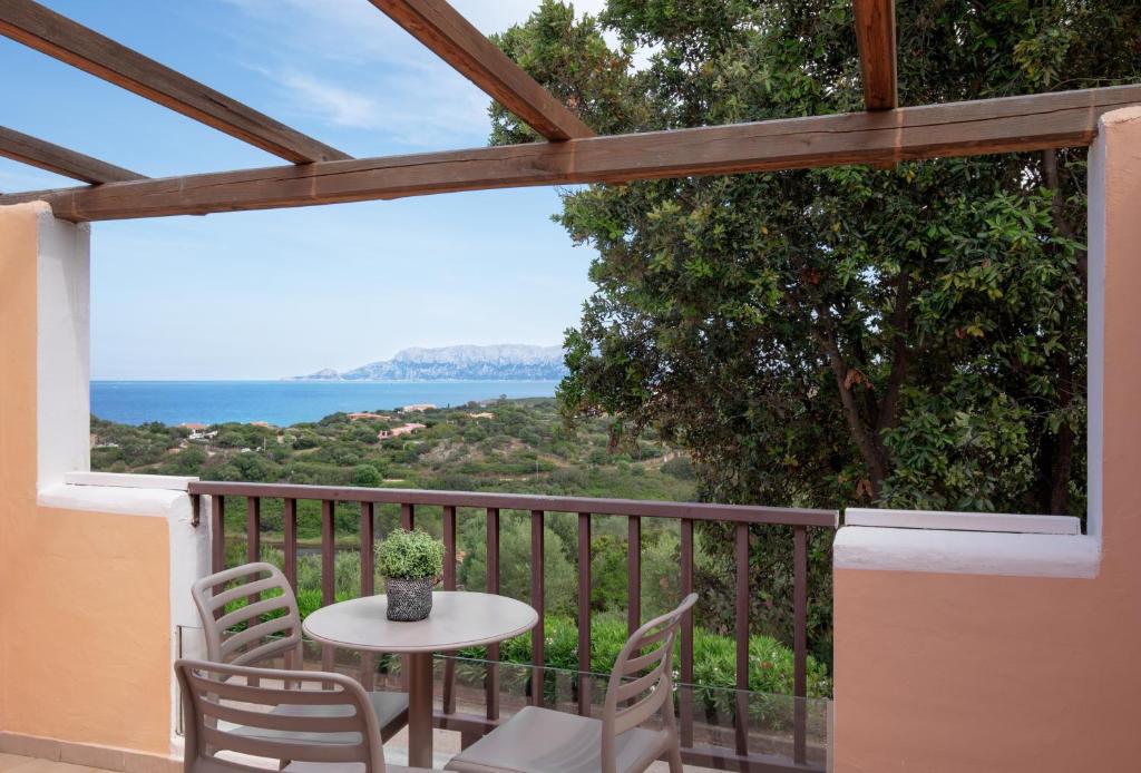 Skats no balkona uz jūru un apkārtējo ainavu ar galdu un krēsliem. Ideāla vieta atpūtai un relaksācijai.