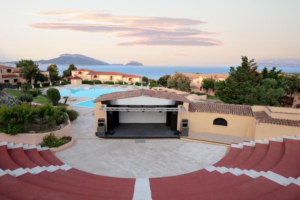 Skatuve pie baseina ar skatu uz jūru un apkārtējiem mājokļiem, izceļot brīnišķīgu ainavu un relaksējošu atmosfēru.