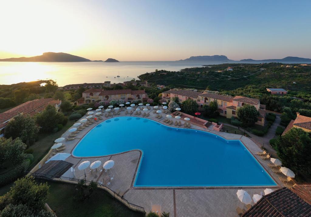 Mājas viesnīcas baseins ar saule un jūras skatu, apkārt esošās ēkas un dārzs. Ideāla vieta atpūtai un relaksācijai.