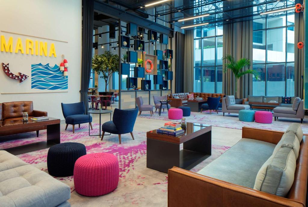 Mūsdienīgs Rove Dubai Marina vestibils ar košiem akcentiem.