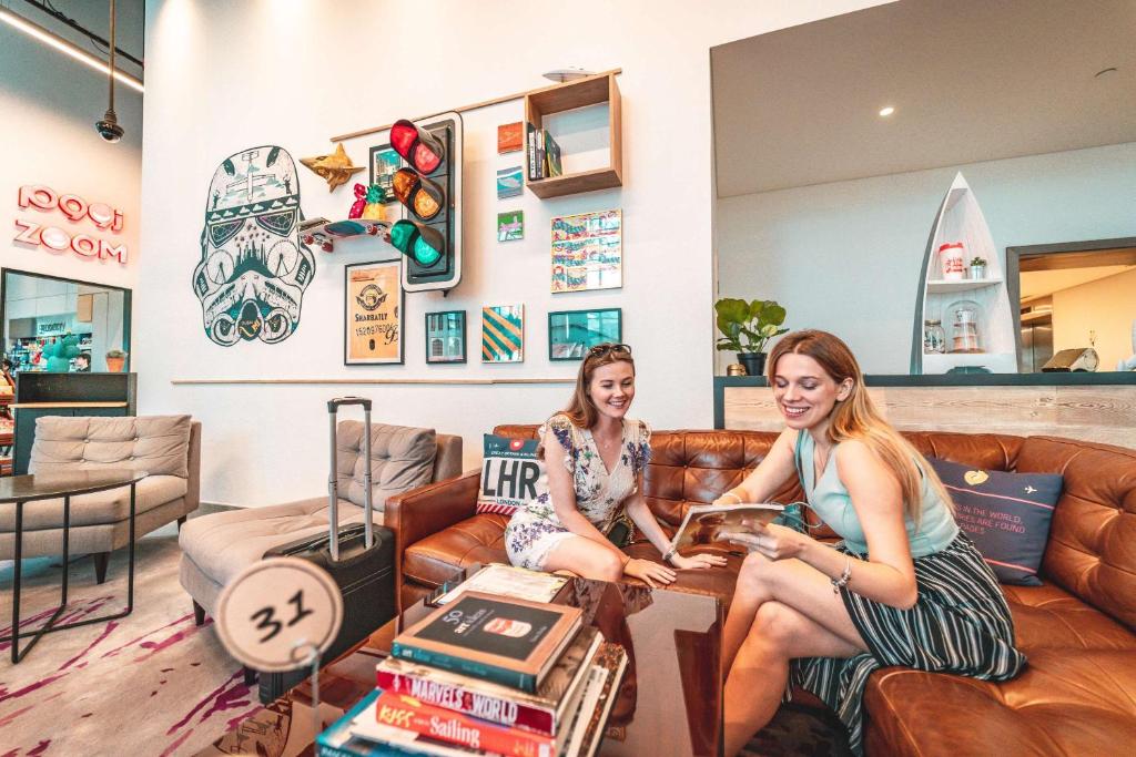 Rove Dubai Marina modernā atpūtas telpa ar viesiem.