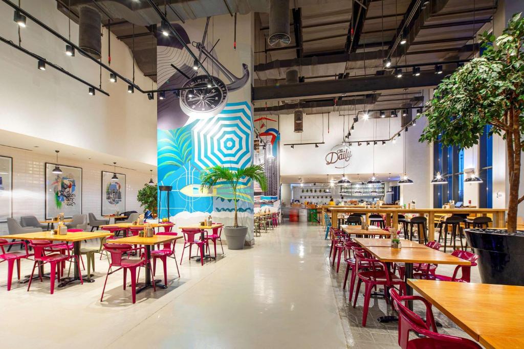 Rove Dubai Marina viesnīcas moderns restorāns ar spilgtām sienām.