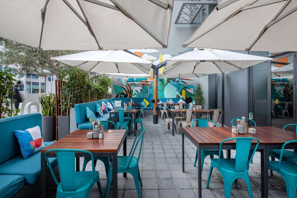 Rove Dubai Marina āra terase ar atpūtas zonu un saulessargiem.