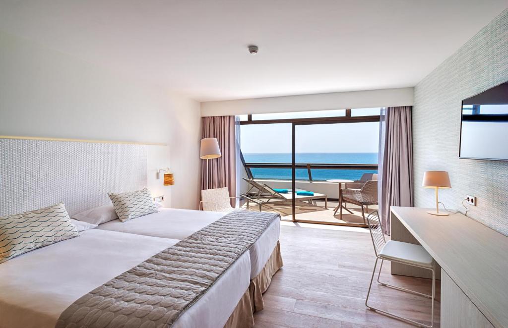 Mūsdienīgs viesnīcas numurs ar divām gultām, jūras skatu un balkonu. Numurā ir televizors, galds un ērtas krēsli.