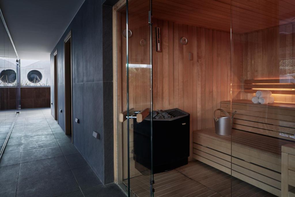 Mūsdienīga sauna ar koka apdari un stikla durvīm, radot relaksējošu atmosfēru. Gaisma un siltums veicina mierīgu atpūtu un labklājību.